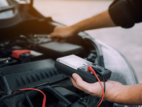 technician testing battery with a power probe